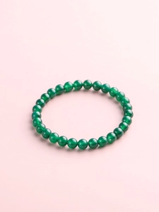 Detailed view of polished green jadeite round beads with smooth translucent texture