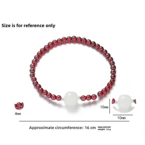 Detailed macro view of 4mm garnet beads and 10mm jadeite stone on 16cm silver bracelet