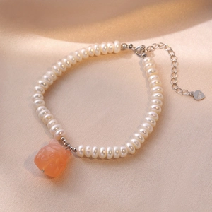 S925 silver freshwater pearl bracelet with carved agate fox pendant on silk background