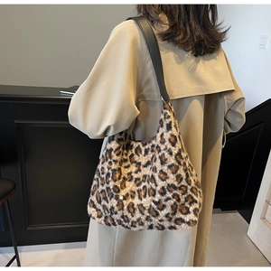Dettaglio della borsa tote in pelliccia sintetica leopardata con tracolla nera su cappotto
