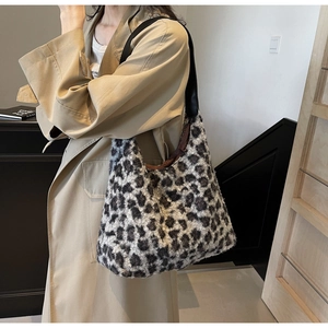 Dettaglio borsa shopper in ecopelliccia leopardata con ampia tracolla in pelle nera di tendenza