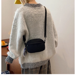 Borsa a tracolla minimalista in nylon nero con tracolla regolabile, vista laterale casual