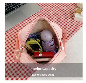 Internal capacity of pink canvas crossbody bag showing phone, umbrella and sunglasses