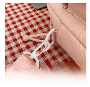 Detail of pink nylon crossbody bag showing premium white swivel hook and strap attachment