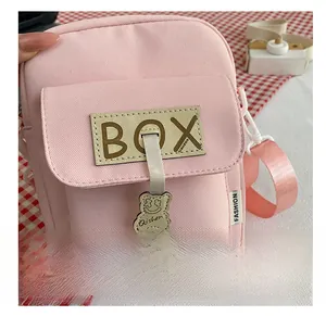 Pink nylon crossbody bag detail with BOX charm and cute bear keychain accessory