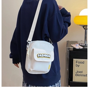 Detailed view of white canvas crossbody bag with Fashion embroidery and wide strap
