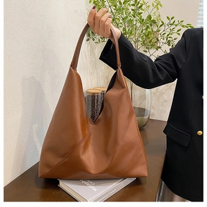 Detailed close-up of brown faux leather shoulder bag with diagonal quilted stitching