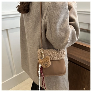 Detail of a brown lamb wool and suede crossbody bag shown on model for size and style