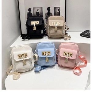 Detail showing five colorful small crossbody bags with cute bear charms on white steps