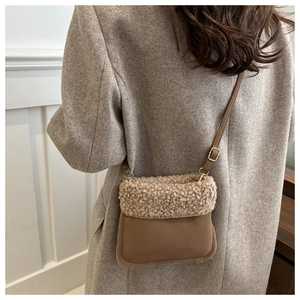 Detail view of mini crossbody bucket bag with fuzzy sheepskin flap and brown strap