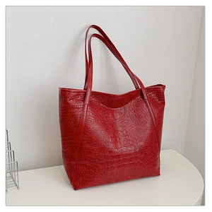 Detail showing red crocodile pattern texture and spacious interior of the tote bag