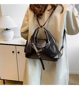 Detail of dark brown vintage faux leather backpack with retro gold hardware and flap