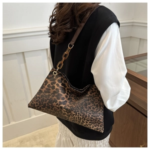 Detail of leopard print tote bag with amber acrylic chain and brown shoulder strap