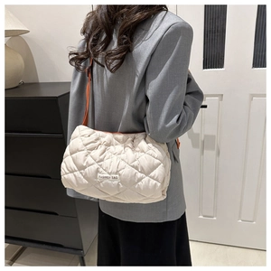 Quilted beige puffer shoulder bag with orange strap and large diamond stitching