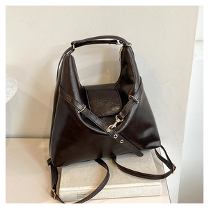 Vintage brown leather tote bag with dual straps on book for commute and class