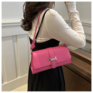 Close-up of pink crocodile texture shoulder bag with silver H-buckle on a model