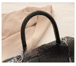 Detailed macro view of black crocodile pattern leather and silver metal chain link