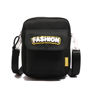 Modern black crossbody bag with white plush fashion patch and adjustable strap