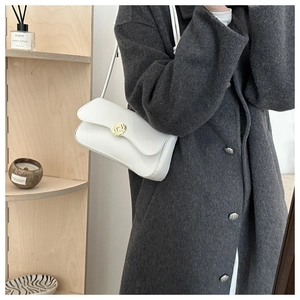 Detail of elegant white PU leather shoulder bag with gold circular metal buckle for women