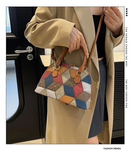Détail du sac à main en patchwork avec texture crocodile et garnitures dorées sur modèle
