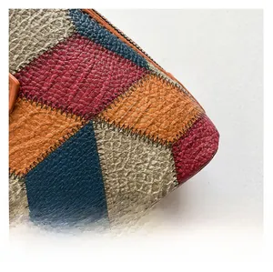 Close-up of color-block shell bag showing premium lychee texture leather and stitching