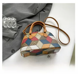 Top view of geometric multi-color patchwork shell bag with handles and shoulder strap