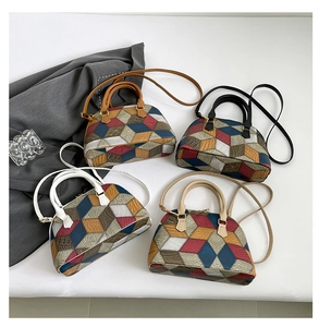 Detailed overhead view of four geometric color-block shell bags with top handles and straps
