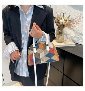 Détail du sac coquille multicolore avec motif en losange et poignée supérieure blanche
