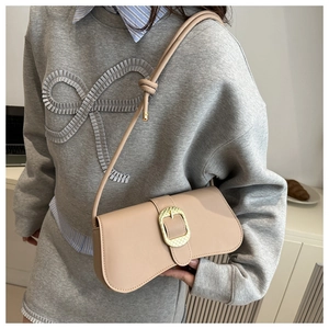 Détail du sac bandoulière beige élégant avec fermoir doré texturé et bandoulière nouée