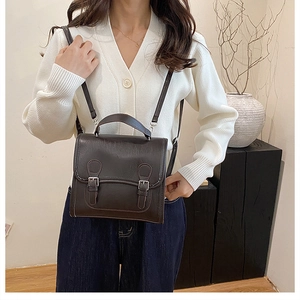 Detail of a dark brown vintage British style satchel with matte leather and buckle closure