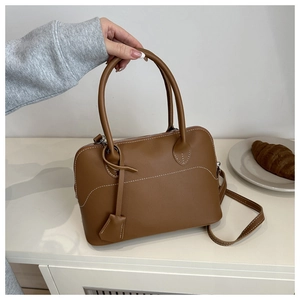 Brown matte leather Boston bag with white stitching detail and round top handles