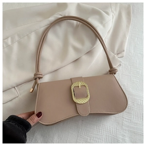 Détail du sac baguette rose nude avec une grande boucle dorée et bandoulière en corde