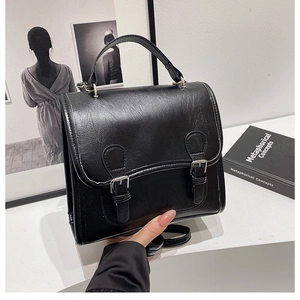 Detail view of the black retro Cambridge bag with silver buckles and leather texture