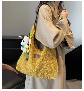 Detail of mustard yellow fuzzy tote bag with brown leather strap and white puppy charm