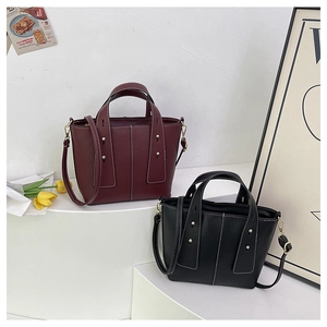 Litchi pattern leather tote bag with contrast stitching in burgundy and black colors