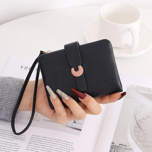 Detail of black litchi texture women's wallet with rose gold C-shaped metal buckle and strap