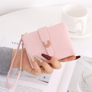 Pink lychee grain leather short wallet with metal buckle and wrist strap detail