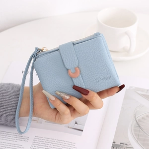 Detail of light blue lychee pattern wallet with golden crescent buckle and wristlet strap