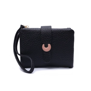 Detail of black lychee grain leather wallet featuring a rose gold horseshoe buckle closure