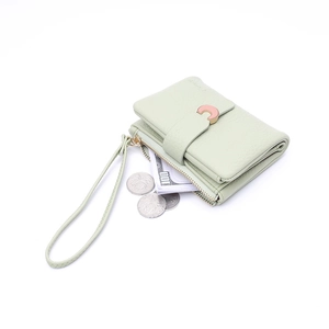Detail view of mint green wallet showing pebble texture, C-shaped buckle and hand strap