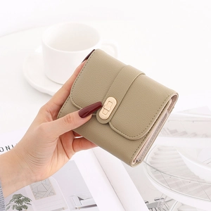 Detailed close-up of khaki pebbled leather wallet with elegant gold metal buckle closure