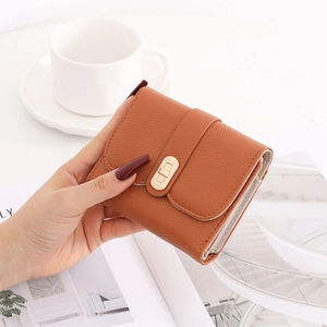 Close-up of caramel brown lychee leather folding wallet with golden twist lock closure