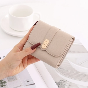 Close-up of a beige textured leather short wallet with a gold twist lock and card slots