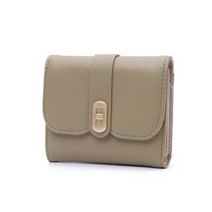 Detail of taupe litchi leather wallet featuring a gold Lucky twist lock closure