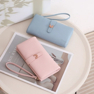 Detail of long leather wallets in blue and pink with wrist straps and metal buckles