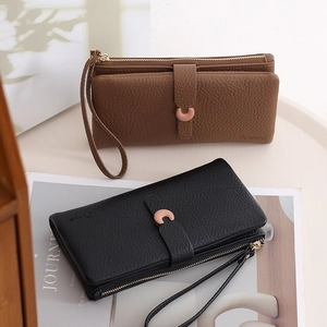 Detail of long leather wallets with C-buckle and zipper in black and brown colors