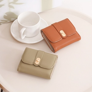 Detailed view of women's leather tri-fold wallets with textured grain and gold metal clasps