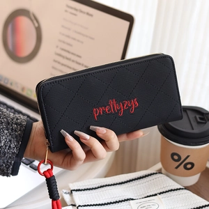 Detail of black woven long wallet with red embroidery and a braided wrist strap