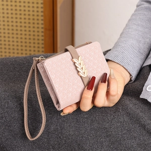 Detail of pink leaf buckle wallet with woven texture and matching wrist strap