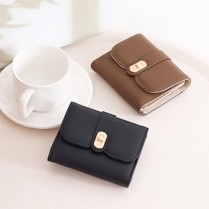 Detail of short wallets in black and brown leather with litchi texture and metal locks